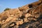 Large boulders are scattered along the rocky mountain slope. Blue sky above