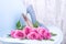 A large bouquet of pink roses on a blue chair in women`s shoes with thin heels. New shoes and flowers. A gift for a woman on
