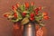 A large bouquet of red flowers in a vase. The woman is holding a large bouquet of red tulips in a watering can. Card for valentine