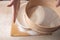 Large bowl, cutting board, sieve for sifting flour on the table. Female hands sifting flour in the home kitchen