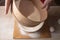 Large bowl, cutting board, sieve for sifting flour on the table. Female hands sifting flour in the home kitchen