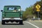 Large Boxer dog rides back in the old green pickup truck Chevrolet