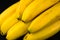 A large branch of bananas on a black background. Close-up.