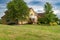 Large brick country house with trees and expansive front lawn