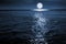 Large Bright FUll Moon Rises Over A Calm Ocean Scene