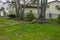 A large broken tree branch laying on the grass near a house.