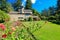 Large brown house exterior with summer garden.