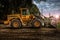 Large bulldozer at construction site, cloudy sky and sunset