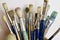 Large bunch of used artist`s paintbrushes upright in a jar