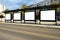 A large bus stop against a beautiful sky in a modern city with empty advertising banners inside