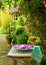 A large bvowl of crockery filled with water and many swimming leafs of pink flowers on a wooden table in front of a beautiful flow