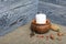 A large candle in a clay vessel. Acorns and rowan berries are scattered nearby. Against the background of brushed boards