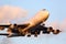 Large cargo aircraft approaching the airport at sunset