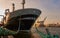 Large cargo ship is moored with green ropes to the bollard of the pier