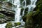 Large cascading waterfall in a mountain forest.