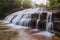 Large cascading waterfall over slates and cliffs of rock