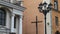 A large Catholic crucifix and a street lamp at the entrance to the church. The concept of worship and faith in God.