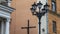 A large Catholic crucifix and a street lamp at the entrance to the church. The concept of worship and faith in God.