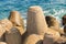 Large cement block breakwater powerful protection of the coastline from the stormy waves of the sea against a background of azure