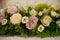 Large centerpiece with pastel color roses and fresh foliage