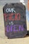 Large chalkboard sign that says ` Our patio is open, ` inviting people to come in and relax for awhile