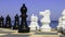 Large chess pices alongside the ocean