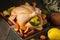 A large chicken stuffed with an apple, ready for baking, lies on a baking sheet