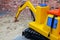 Large childrens yellow excavator in the playroom sandbox