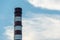 A large chimney against the sky and clouds. Environmental pollution. Emission of harmful substances into the atmosphere.