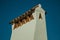 Large chimney covered by rough plaster and rooftop