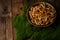 A large clay bowl with wild mushrooms honey mushrooms, stands on an old wooden table with green moss. Eco products, natural