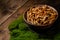 A large clay bowl with wild mushrooms honey mushrooms, stands on an old wooden table with green moss. Eco products, natural