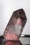 Large clear crystal of quartz chalcedony illuminated with red highlights white closeup