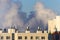 A large cloud of smoke over the roofs of apartment buildings