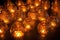 large cluster of small flickering oil lamps in a darkened room