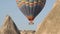 Large coloured hot air balloon with tourists in brown basket