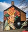 Large colourful wall mural of lady with flowered head piece in Glastonbury, Somerset, UK