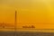 A large commercial cargo ship stands on a roadstead against a cable-stayed Russian bridge