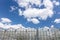 Large commercial greenhouse glass facade against blue cloudy sky