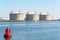 Large concrete tanks at a liquefied natural gas terminal on asunny day