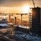 Large construction site including several cranes working on a building complex, with evening sunset, gold sunlight, construction