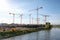 Large construction site with many cranes on a river, on a sunny, hazy day - Berlin 2018