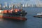 A large Container ship being gently pushed to a dock at the Cartagena Harbor