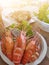 These large, cooked prawns are ready to be eaten in white cups. Soft background, warm light