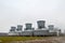 Large cooling towers in water and fog at an oil refinery, petrochemical, chemical plant.