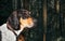 Large coonhound in front of dark defocused forest background.