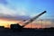 Large crawler crane or dragline excavator with a heavy metal wrecking ball on sunset background. Wrecking balls at construction