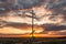 A large cross stands on a hill overlooking the steppe village against the backdrop