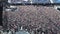 Large crowd people at a large stadium, preparing for a rock concert, a lot of people