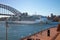 Large cruise ship driving under the bridge over the bay and the embankment, Harbour Bridge, Sydney